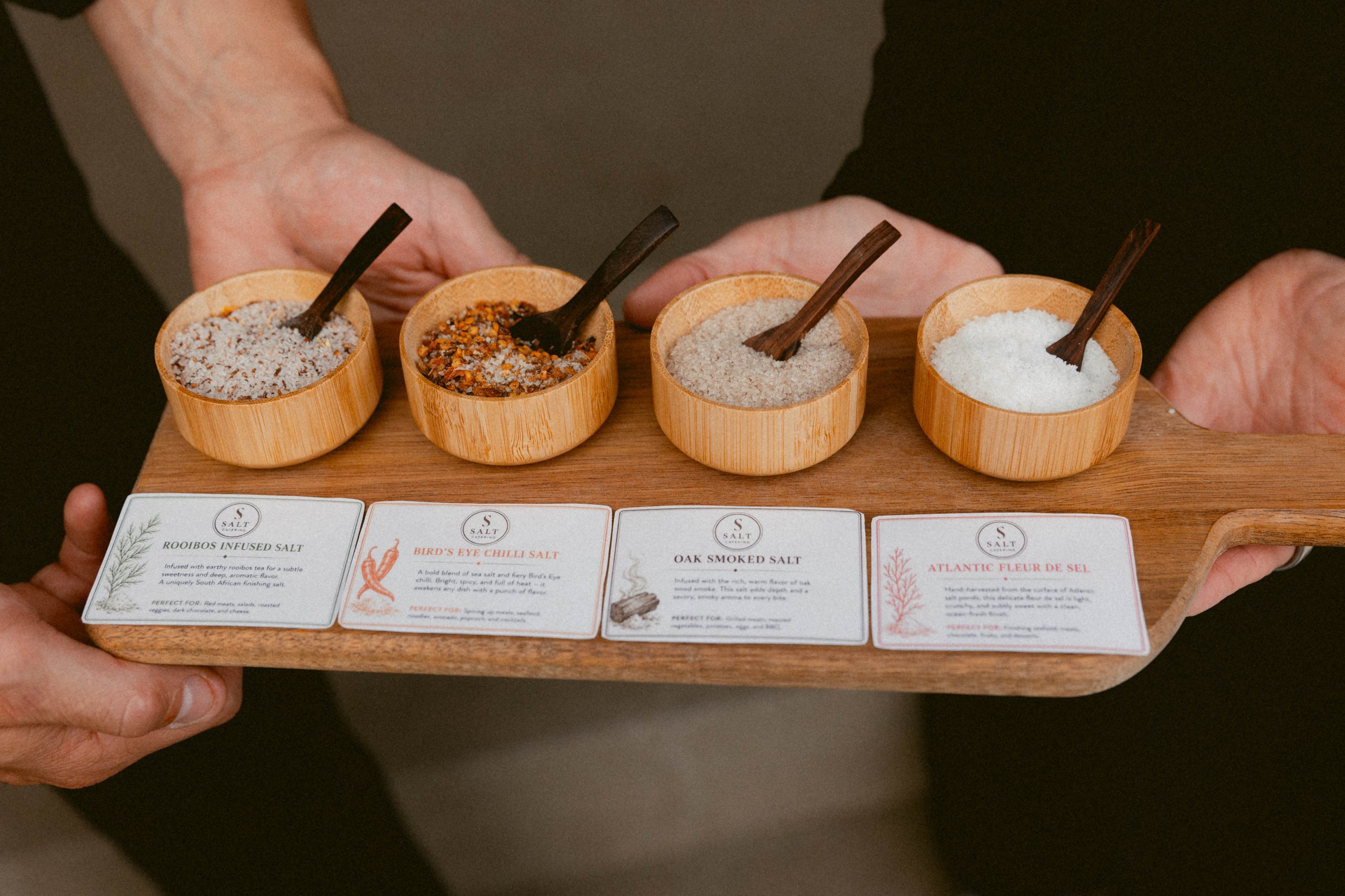 A Salt Catering salt flight of four finishing salts, served on a wooden board